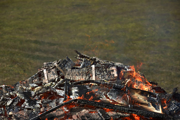 Remnants of burning wooden crates. Burning fire. The smoldering fireplace.