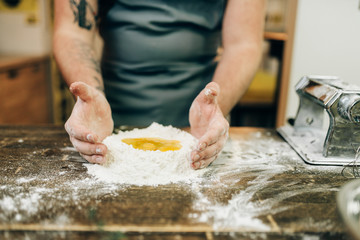 Pasta cooking, bearded chef preparing dough
