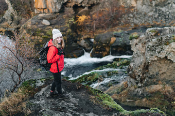 Obraz premium One woman wanders in Iceland with black backpack in a red jacket