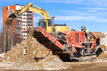 Fototapeta premium Crawler Mobile Crusher and excavator Crushing concrete.