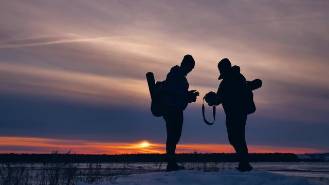 two tourists happy silhouette photograph nature travel at sunset climb the mountain experience the joy .winter trip travel men with backpacks silhouette light sunny sunset
