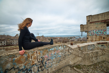 Fototapeta na wymiar Young slim brunette on a ruins of abandoned building