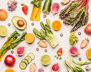 Colorful fruits and vegetables flat lay background with half of oranges,avocado, citrus,apples and berries , top view. Healthy food and clean eating ingredients concept