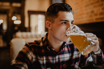 Young man with drink beer in a bar