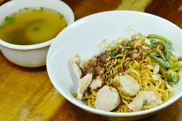dry Chinese yellow noodles topping slice pork and ball dressing sweet black soy sauce with soup