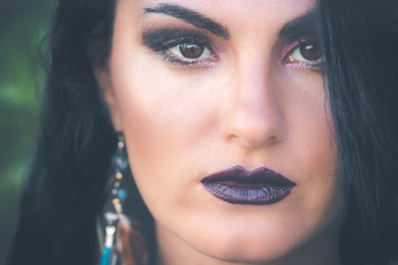 Beauty Woman Face. Portrait Of Beautiful Sexy Young Female With Perfect Facial black Makeup, Outside green background.