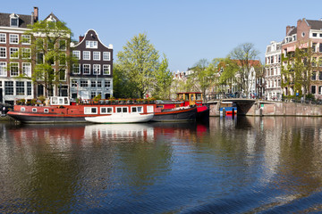 Gracht Fluss schöne Sehenswürdigkeit in Amsterdam vor blauen Himmel