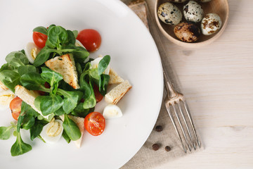 salad with quail egg, cherry tomato, crackers and corn salad on white background