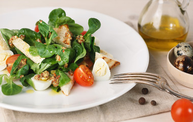 salad with quail egg, cherry tomato, crackers and corn salad on white background