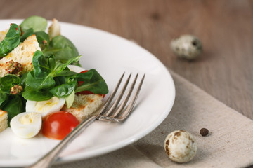 salad with quail egg, cherry tomato, crackers and corn salad on wooden background