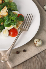 salad with quail egg, cherry tomato, crackers and corn salad on wooden background