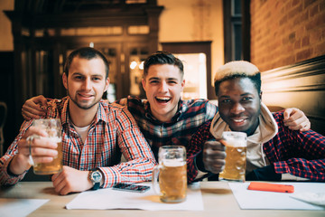 happy students male friends drinking beer at bar or pub