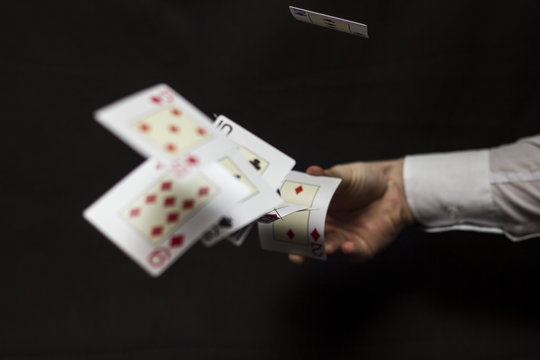 Flying playing cards with hand on a dark background