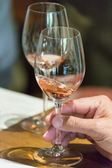 A man swirls a glass of rose wine at a wine tasting