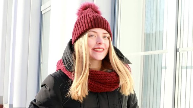 portrait of a beautiful, happy, young girl in a knitted cap and scarf.