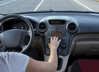 Woman searching radio station while she is driving. Cause of Distracted Driving Accidents concept
