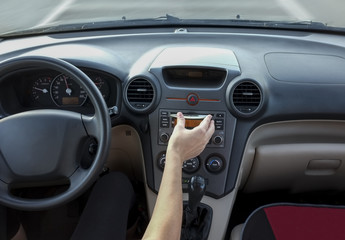 Fototapeta na wymiar Woman inserting CD Audio while she is driving. Cause of Distracted Driving Accidents concept