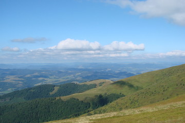 Panorama of the blue Carpathian sky at the level of the cloudy strip above the mountain forests.
