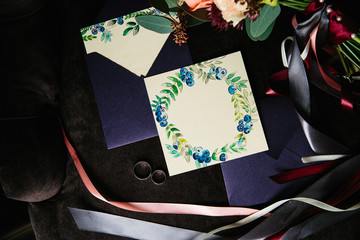 Workspace. Wedding invitation cards, Kraft envelopes, purple and blue berries and green leaves on white background. Wedding ring. The view from the top. Laying flat, top view