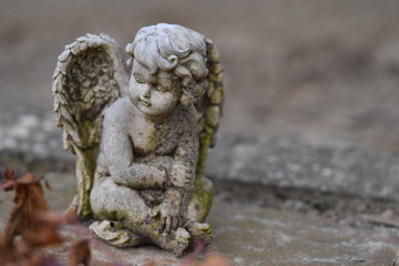 Fototapeta premium Weathered sculpture of a little angel