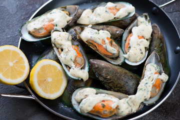 Black bowl with raw kiwi mussels, close-up, selective focus, horizontal shot