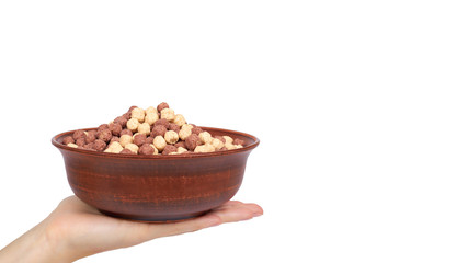 Chocolate breakfast cereal in bowl in hand isolated on white background, brown and white balls, healthy morning food. copy space, template