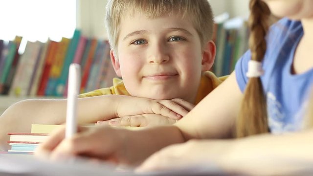 Portrait of a funny boy with a book. An elementary school student in class. 
