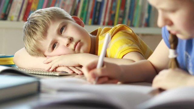 Bored and tired child.  A sad child in class. Elementary school student   at classroom.