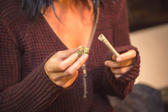 Woman Holding Cannabis Buds and Joint