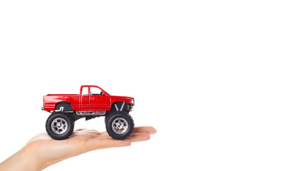 big metal red toy car offroad with monster wheels in hand isolated on white background. copy space, template