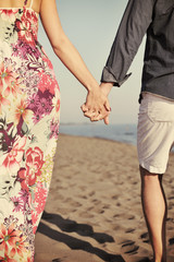 couple on beach with travel bag