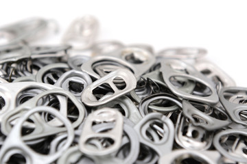 Obraz na płótnie Canvas Heap of ring pulls with one pull tab in focus