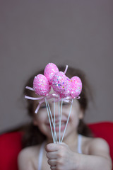 Little kid girl holds pink easter eggs in hands and laugh or smile.
