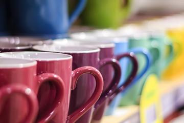 set of colorful mug cups on a old wooden table, blurred background