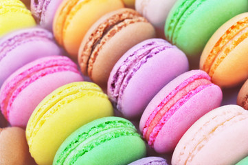 Colorful macarons on bright festive decor background, selective focus