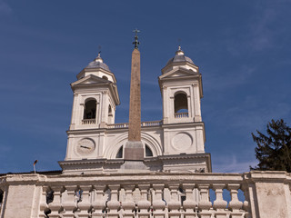 Obraz premium Die Kirche Santissima Trinita dei Monti in Rom mit dem davor stehenden Obelisk an einen klaren sonnigen Tag mit strahlend blauem Himmel