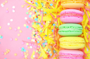 Colorful macarons on bright festive decor background, selective focus