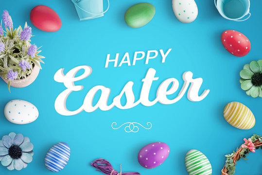 Happy Easter greeting text on blue background surrounded with colorful eggs and decorations.