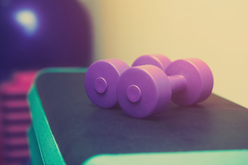 plastic dumbbells in a sports hall, close-up. Sports concept, fat burning and healthy lifestyle.