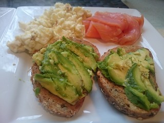 Salmon, scrambled eggs and avocado on toast breakfast