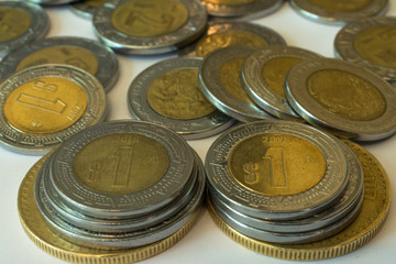 Muchas monedas de México están en la mesa. 