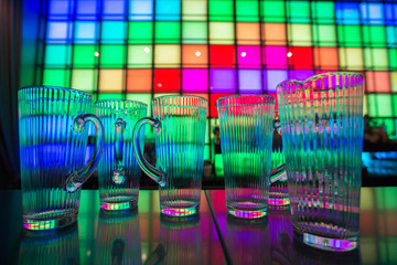 
Glass dishes in color lights background

