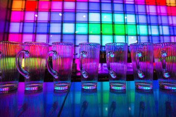
Glass dishes in color lights background

