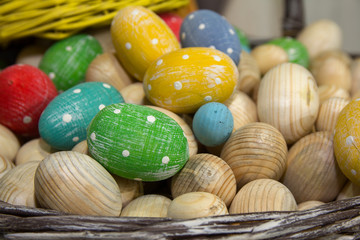 Decorative wooden easter eggs in a basket. Holiday