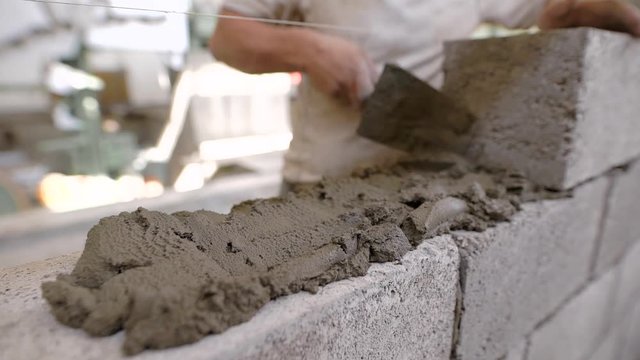 Close up of a bricklayer on a construction site with a trowel