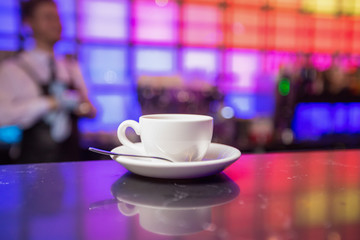 White teapot and tea cup on color lights background
