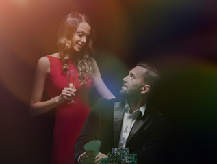 beautiful couple looking at playing cards at poker