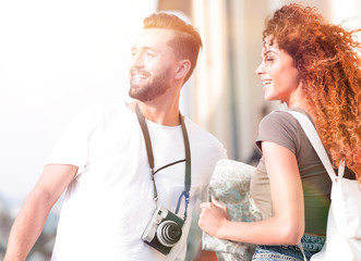 Young couple walking and looking at a guide while looking happy