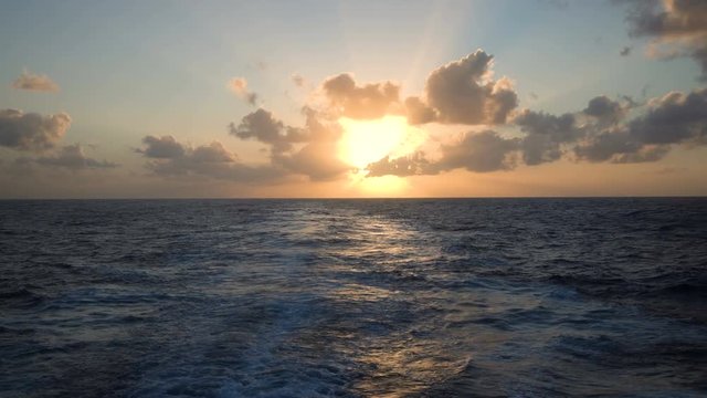 Wake behind an ocean going cruise ship at sea with sunset