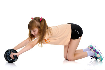 Fototapeta na wymiar A little girl does gymnastic exercises.